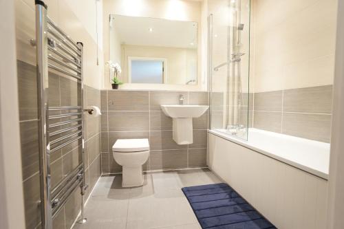 e bagno con servizi igienici, lavandino e vasca. di Perfectly located stunning apartment a Londra