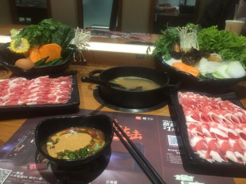 una mesa cubierta con tazones de sopa y verduras en Tianjin Huangyaguan Great Wall Home Hotel, en Jixian