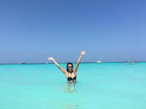 a woman in the ocean with her arms in the air at Mocco Beach Villa in Kendwa