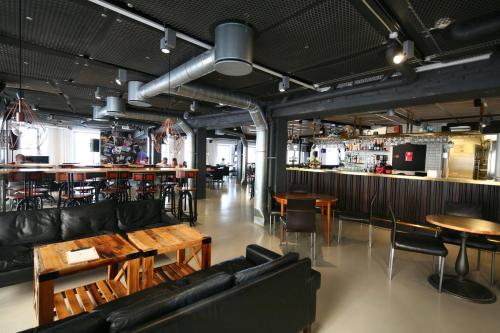 un restaurante con sofás y mesas y un bar en Urban House Copenhagen by MEININGER en Copenhague