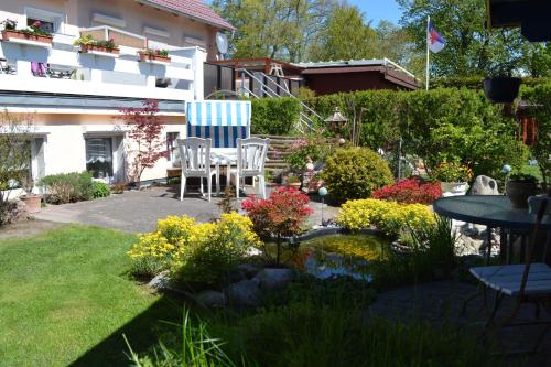 a garden with a table and chairs and flowers at Ferienunterkuenfte Buggenthin in Zinnowitz