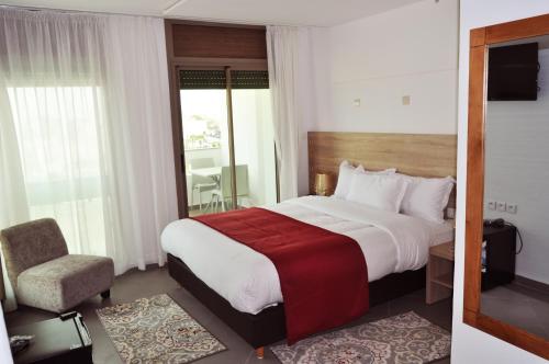 a hotel room with a large bed and a chair at Dakhla Sur Mer Hôtel in Dakhla