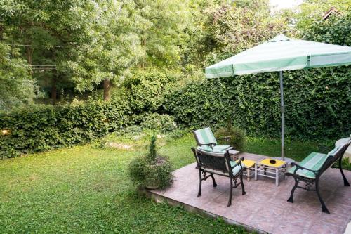 a patio with two chairs and an umbrella at Vila Mila in Arandjelovac