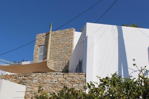 a church with a cross on top of a stone wall at Guesthouse Casa De La Roca , Kostos , Paros in Kóstos