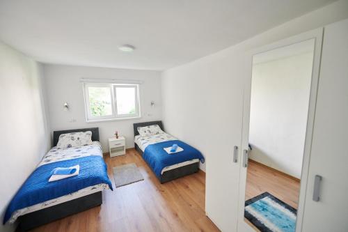 sypialnia z 2 łóżkami i oknem w obiekcie Lovely House Apartment w Sarajewie