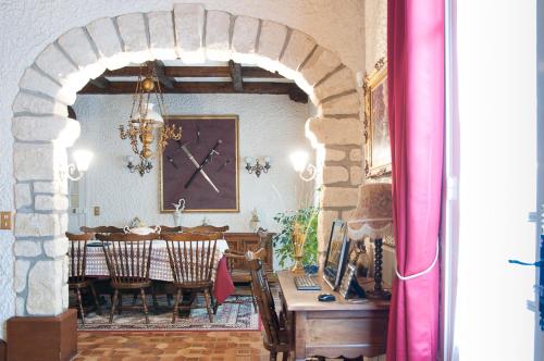 a dining room with a table and a clock on the wall at Maison Lalongère in Longueville