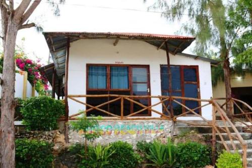 a small white house with blue windows at Mocco Beach Villa in Kendwa