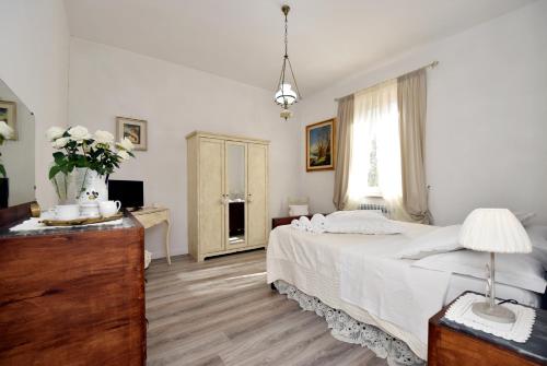 a bedroom with a bed and a dresser and a window at Shabby House Nonna Peppa in Campello sul Clitunno