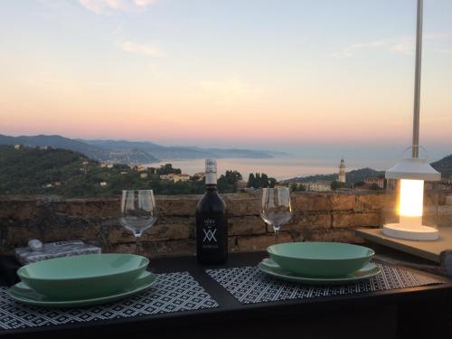 聖馬爾蓋里塔利古雷的住宿－La Mansarda di San Lorenzo，一张桌子,上面放着一瓶葡萄酒和两杯酒