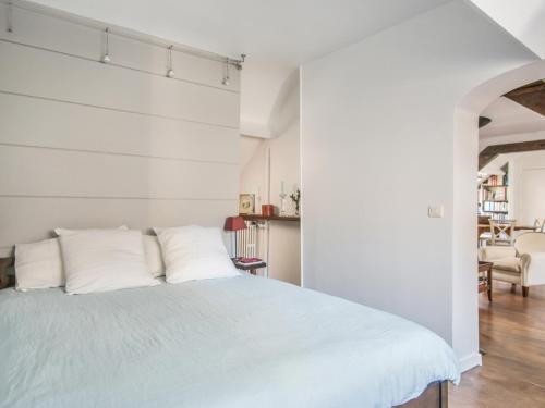 パリにあるWelkeys - Vital Apartmentの白いベッドルーム(大型ベッド1台、白い枕付)