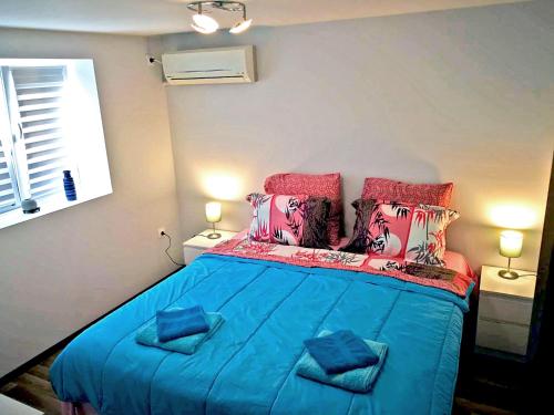 a bedroom with a blue bed with two pillows at Kamenitza Guest Flat in Plovdiv
