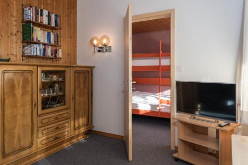 a bedroom with a tv and a bunk bed at Chalet Pfiff in Wildhaus