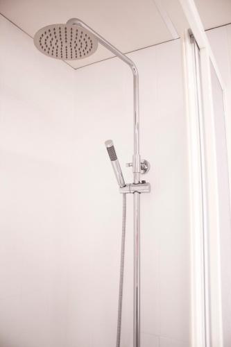 a shower with a shower head in a bathroom at Pensión Mariola in Agres