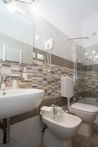 a bathroom with a sink and a toilet and a phone at Hotel San Marco in Reggio Emilia