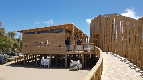 a wooden building with two people on a deck at Carilo Hills by bund in Carilo