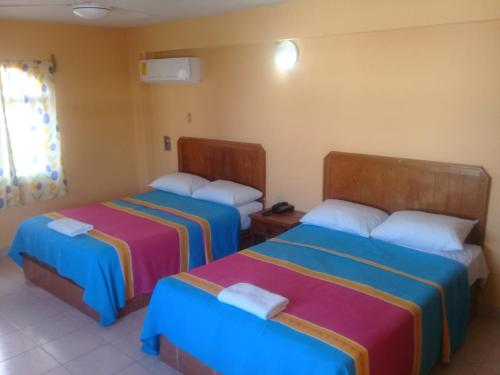 a hotel room with two beds and a window at Hotel Progreso in Progreso