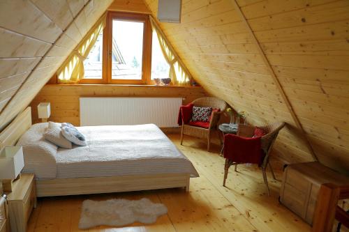 a bedroom with a bed in a wooden attic at Apartament Słoneczny in Kościelisko