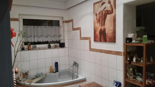 a bathroom with a tub and a window at Übernachten in unseren Crutpracht Gästezimmern mit großem Bauernfrühstück, ab April 24 auch in der DUFFEL-SCHEUNE in Kirchhundem