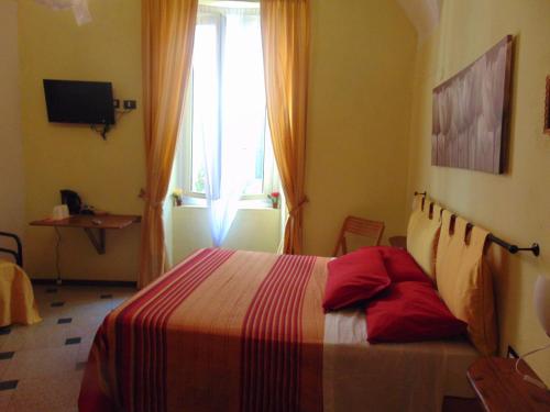 una camera da letto con un letto con una coperta colorata e una finestra di il Pignoletto a Riva Ligure