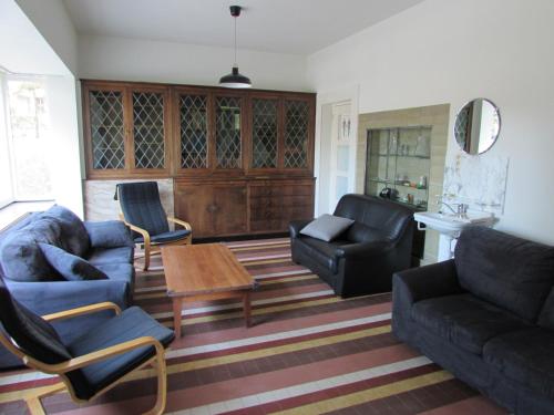 a living room with couches and a table and chairs at De Spreekkamer in Hoogstraten