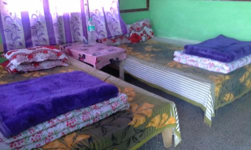 duas camas num quarto com cobertores e mesas roxos em Vamoose Tashi Homestay em Rangpo