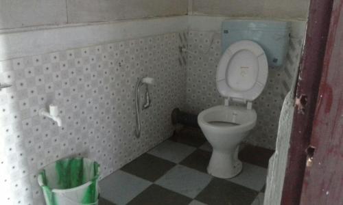 uma pequena casa de banho com WC e piso em azulejo em Vamoose Tashi Homestay em Rangpo