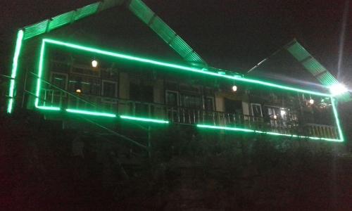 a building with green lights on it at night at Vamoose Tashi Homestay in Rangpo