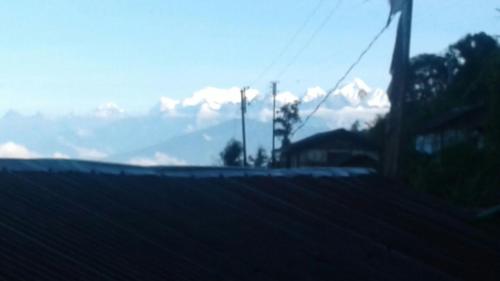 uma vista para uma montanha a partir de um telhado de uma casa em Vamoose Tashi Homestay em Rangpo
