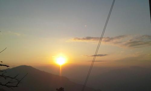 uma vista para o pôr do sol sobre uma montanha em Vamoose Tashi Homestay em Rangpo