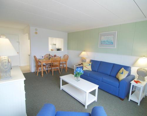 a living room with a blue couch and a table at Sandcastle Resort in Provincetown