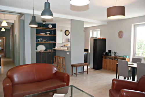 a living room with a leather chair and a table at Gite de Mougeres in Caux