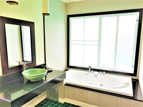 La salle de bains est pourvue d'une baignoire, d'un lavabo et d'une baignoire. dans l'établissement Prima Villas Karon Beach by PHR, à Karon Beach