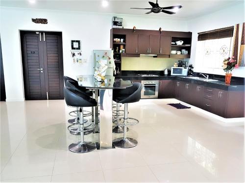 a kitchen with a glass table and black chairs at Prima Villas Karon Beach by PHR in Karon Beach