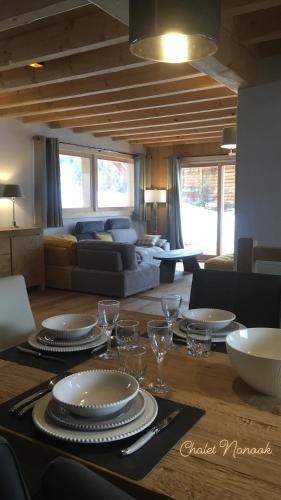 - une table à manger avec des assiettes et des verres à vin dans l'établissement Chalet Nanook, à Notre-Dame-de-Bellecombe