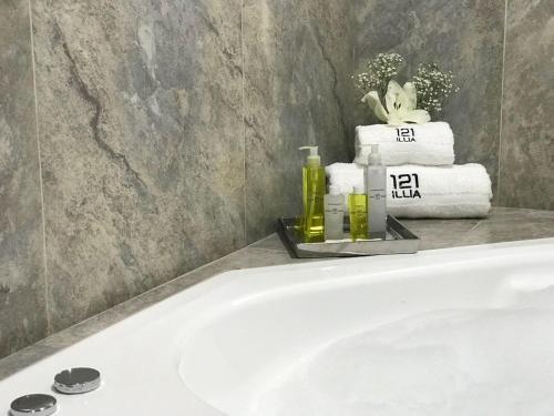 a bathroom with a bath tub with towels and soap at ILLIA 121 APART HOTEL in Neuquén