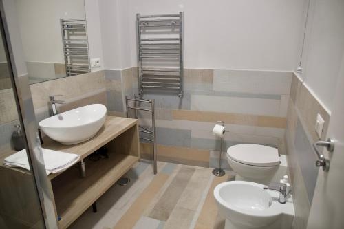 a bathroom with two sinks and a toilet and a mirror at Vista Cupola House in Rome