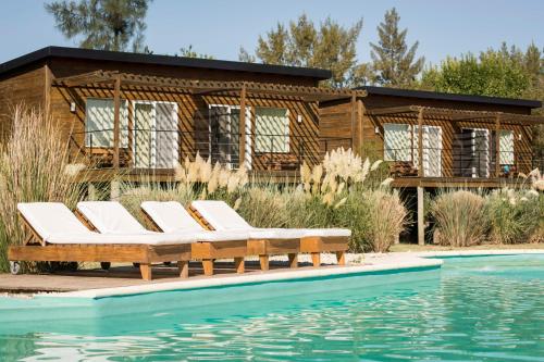 a group of lounge chairs next to a pool at Posada Las Aguas in Gualeguaychú