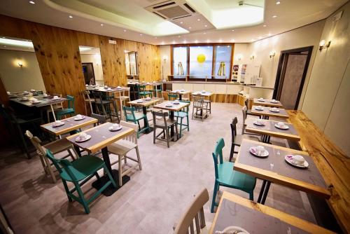 um restaurante vazio com mesas e cadeiras de madeira em Hotel Centrale em Mestre