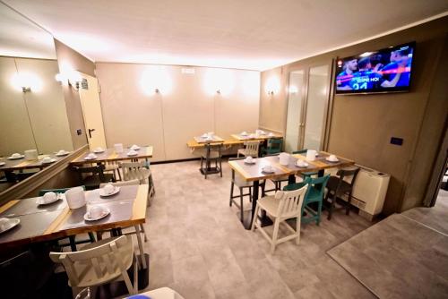 a dining room with tables and chairs and a tv at Hotel Centrale in Mestre