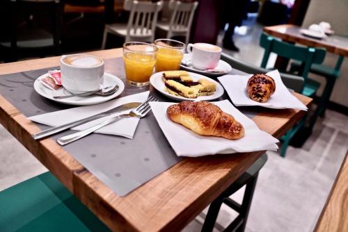 a wooden table topped with plates of food and drinks at Hotel Centrale in Mestre