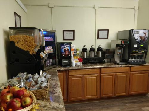 a kitchen with a counter with food and a coffee maker at Thayers Inn in Littleton