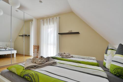 two beds in a room with a mirror at Rieslingstube bei Britta & Joachim in Undenheim