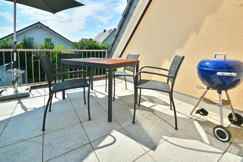 a grill and a table and chairs on a balcony at Rieslingstube bei Britta & Joachim in Undenheim