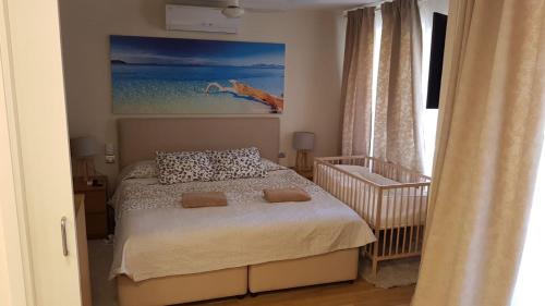 ガバにあるApartamento de lujo en Gava Marのベッドルーム1室(ベッド1台、ベビーベッド1台付)