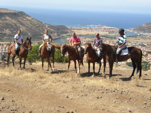 a group of people riding horses on a hill at Hotel Villa Gli Asfodeli in Tresnuraghes