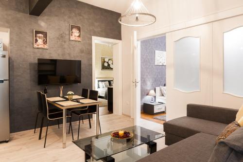 uma sala de estar com uma mesa e um sofá em Vitosha Blvd - 2BR LUX APART em Sófia