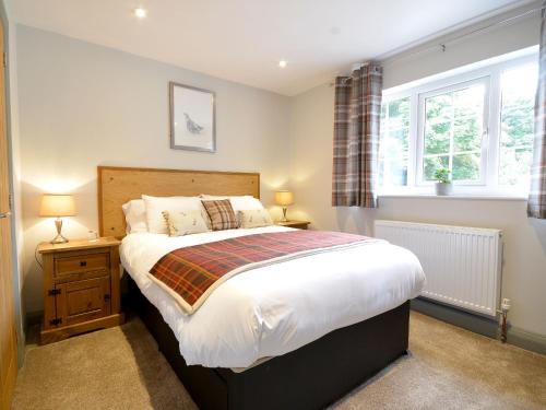 a bedroom with a large bed and two windows at The Cayley Arms Inn in Pickering