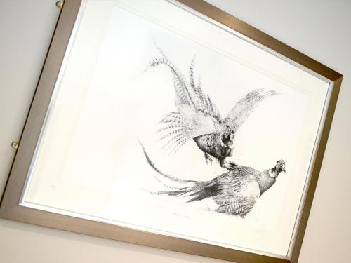 a framed drawing of two chickens on a wall at The Cayley Arms Inn in Pickering