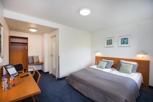 ein Hotelzimmer mit einem Bett und einem Schreibtisch mit einem Laptop in der Unterkunft OnlySleep Trafikcenter in Slagelse