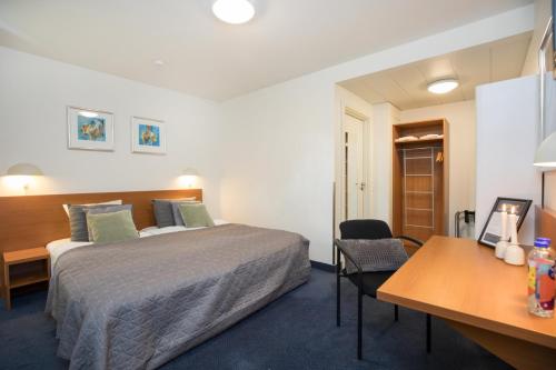 a hotel room with a bed and a desk at OnlySleep Trafikcenter in Slagelse